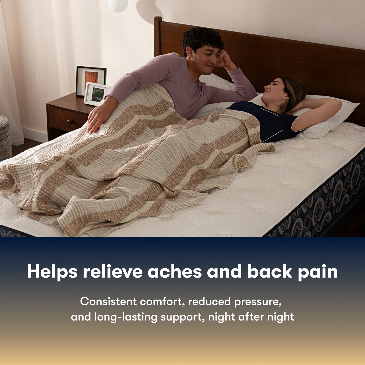 Couple lying on a Serta Perfect Sleeper plush mattress under a striped blanket with text about back pain relief.